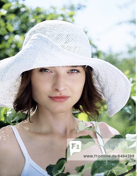 1236867 outdoor summer day people woman young 20-25 girl brunette fringe blouse white portrait close up vertical smile smiling hat