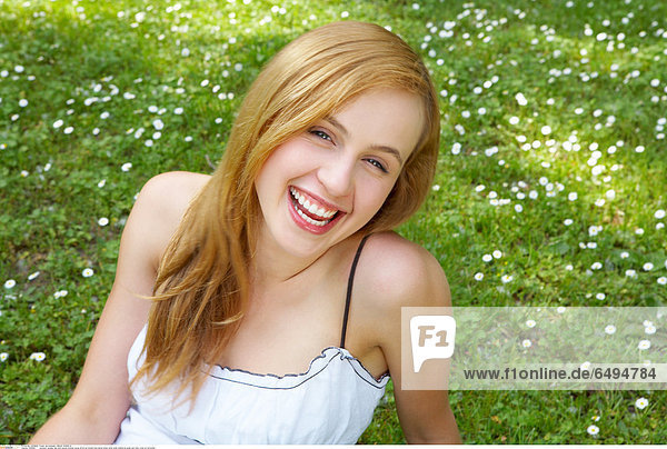 1238993 outodoor summer day park people woman young 20-25 girl blonde long haired dress white smile smiling lie grass rest relax close up horizontal