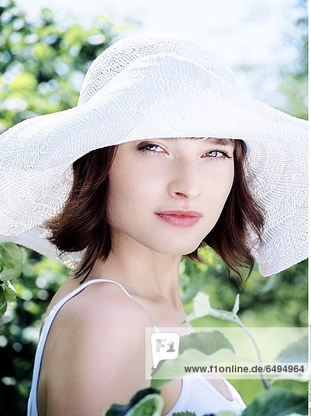 1236881 outdoor summer day people woman young 20-25 girl brunette fringe blouse white portrait close up vertical smile smiling hat