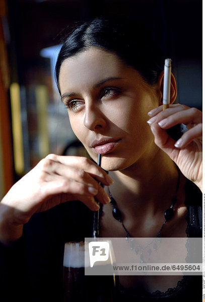 1243787 outdoor day summer people woman young 20-25 girl brunette close up blouse black hold cigarette addiction smoke smile smiling vertical alcohol beer drink relax rest