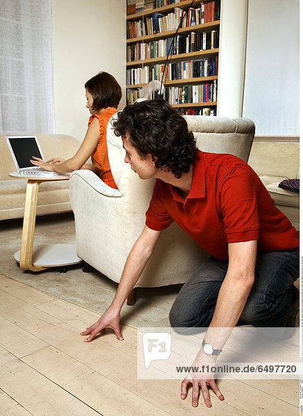 1248649 indoor flat room people woman brunette young 25-30 sit bed blouse orange blouses red rest relax laptop internet communication armchair man couple dark haired crouch look for vertical floor