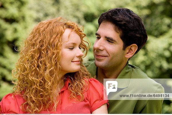 1247260 outdoor day summer park people woman young girl 20-25 blonde long haired smile smiling blouse red couple man 25-30 dark haired blouses green rest relax horizontal close up portrait