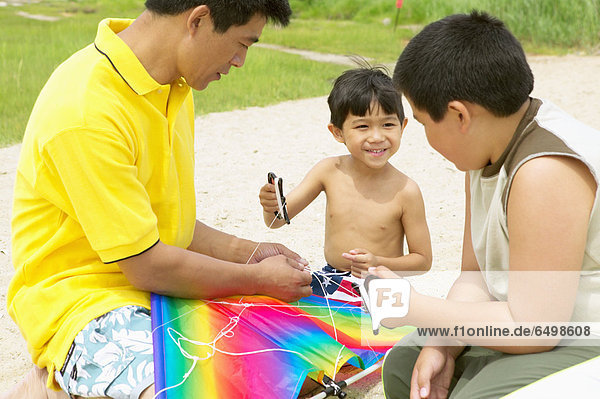 Father and sons flying kite