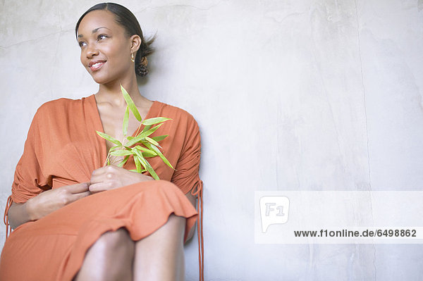 Woman sitting and holding plant