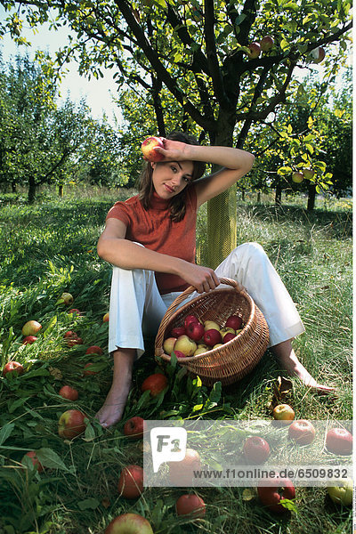 Young woman with apples in the garden.