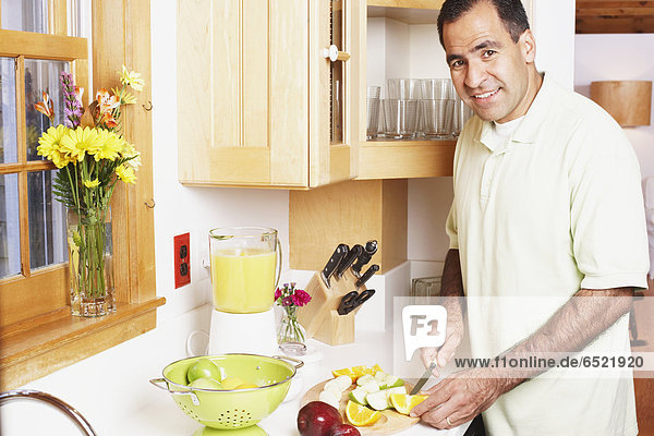 Man chopping fruit in the kitchen
