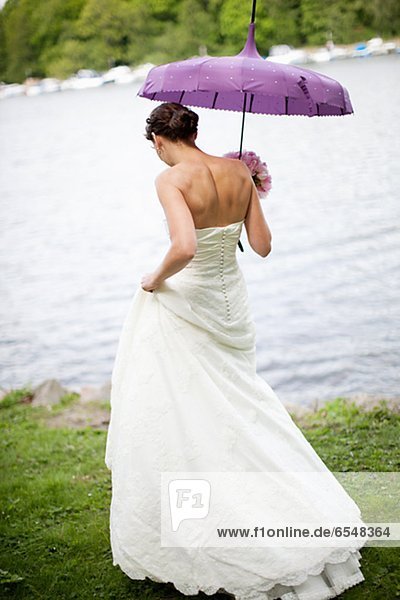 Bride walking on lakeside