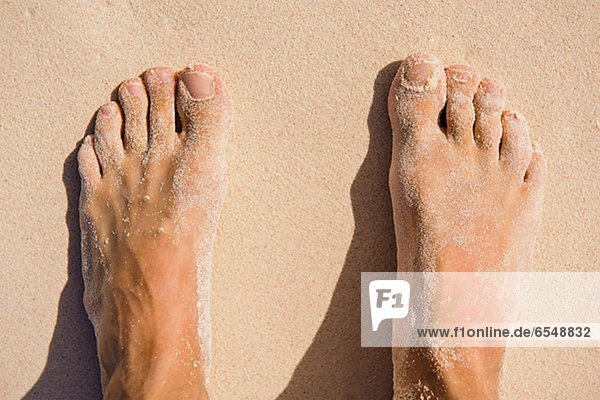 View of mans feet on sand
