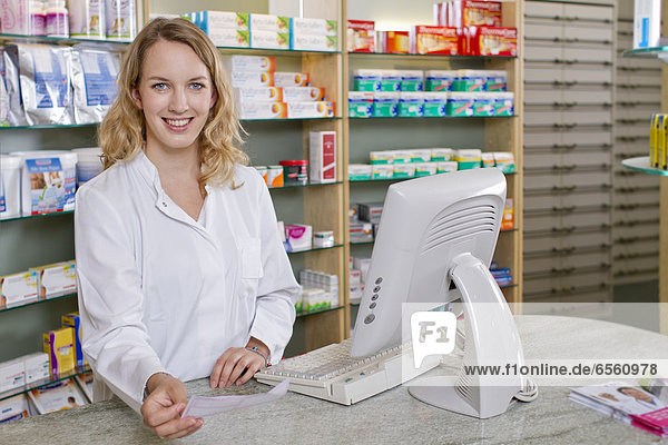 Germany  Brandenburg  Pharmacist holding prescription  smiling  portrait