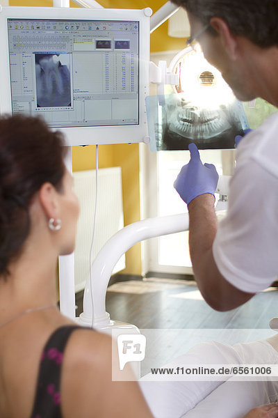 Germany  Brandenburg  Strausberg  Dentist explaining x ray picture to patient