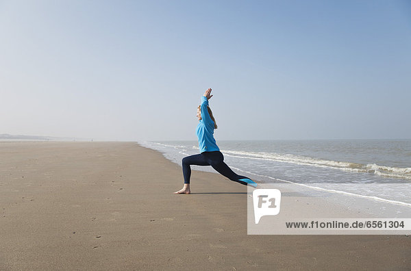 Belgium  Mature woman exercising at North Sea