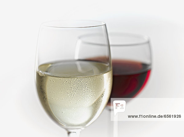 Glasses of white and red wine on white background