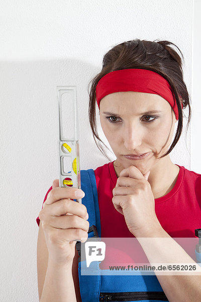 Young woman holding spirit level