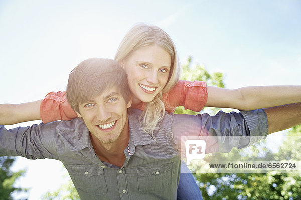 Germany  Cologne  Young couple flying  smiling  portrait
