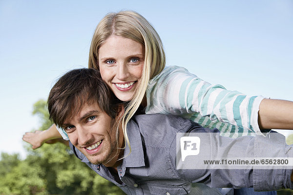 Germany  Cologne  Young couple flying  smiling  portrait