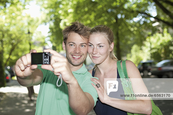 Germany  North Rhine Westphalia  Duesseldorf  Couple taking photo of themselves  smiling