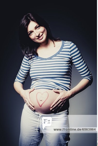 Schwangere Frau mit Herz am Babybauch