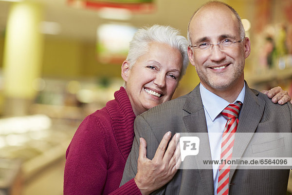 Deutschland  Köln  Ehepaar im Supermarkt  lächelnd  Portrait