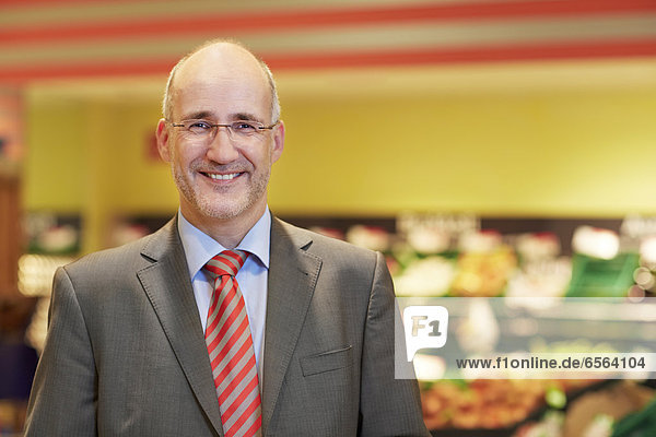 Reifer Mann im Supermarkt  lächelnd  Portrait