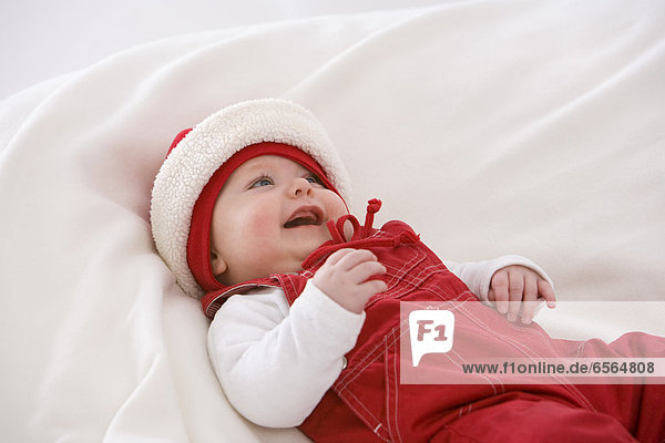 Baby girl lying on baby blanket  smiling