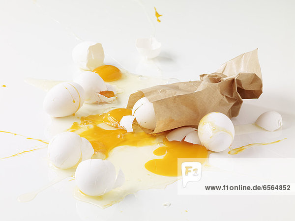 Gebrochene Eier mit brauner Tasche auf weißem Hintergrund  Nahaufnahme