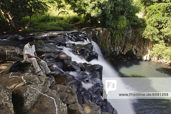 Eine Frau sitzt am Rochester Wasserfall Soulliac Mauritius *** Local Caption ***