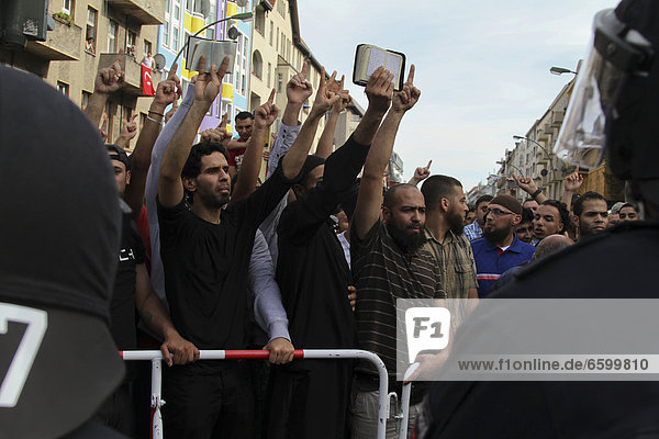Protest against an anti-Islamic rally by the minor political party Pro Deutschland in front of a mosque in Berlin-Neukoelln  agitated demonstrators holding copies of the Koran in the air  Berlin  Germany  Europe