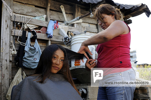 Mother is doing her daughter's hair  10 year old girl  in a poor district of Cancun  Yucatan Peninsula  Quintana Roo  Mexico  Latin America  North America