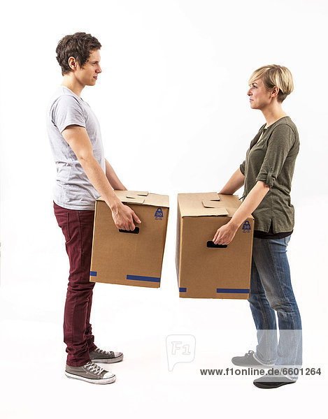 Young couple carrying moving boxes