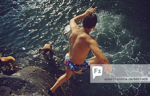 Man Diving Off Of Cliff Into The Ocean