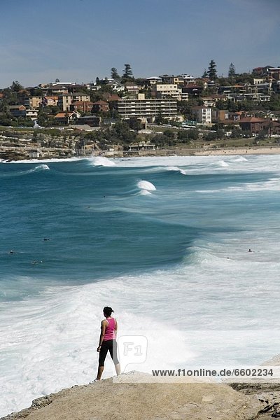 Woman Standing On Rock Over Looking Mackensies And Tamarama Bay  Near Bondi Beach