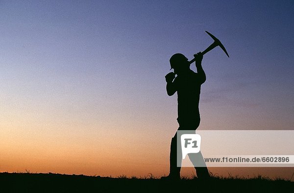 Miner In Silhouette With Pick
