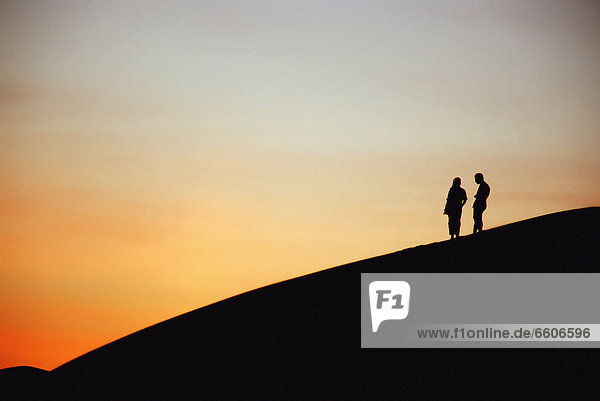 Tourists On Sand Dune At Sunset  Ubari Sand Sea