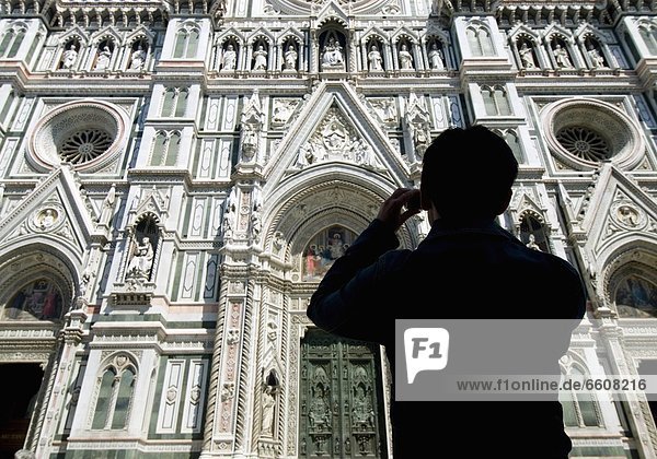 Silhouette Of Woman Taking Photograph Of The Facade Of The Duomo