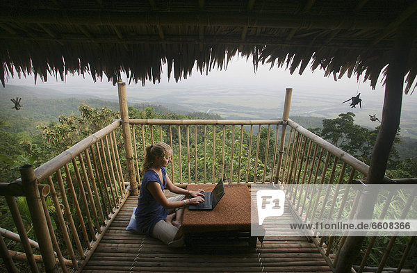 sitzend benutzen Hütte Frau Computer E-Mail Notebook Internet Boden Fußboden Fußböden Balkon Ignoranz übergeben Bambus Bangladesh