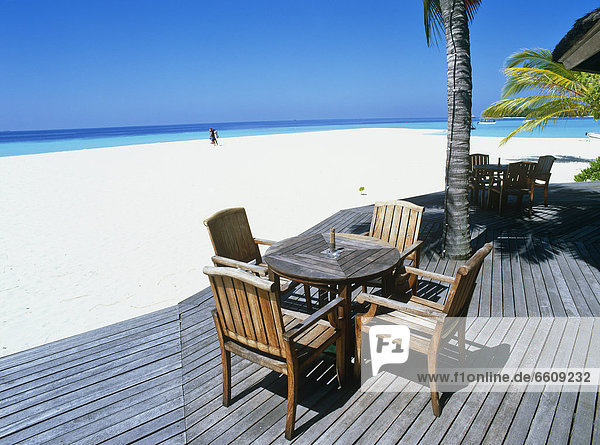 Chairs And Table On Deck By Beach