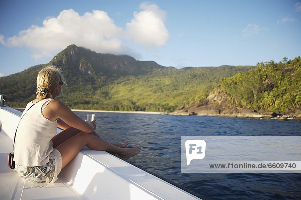 Woman Sitting On Side Of Boat Heading Towards Island