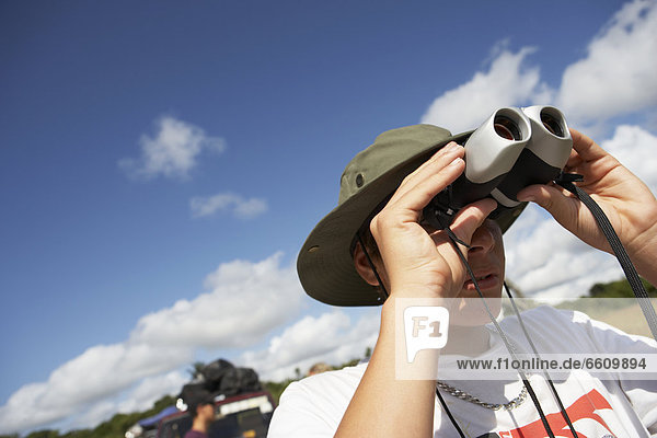 Young Man Looking Through Binoculars