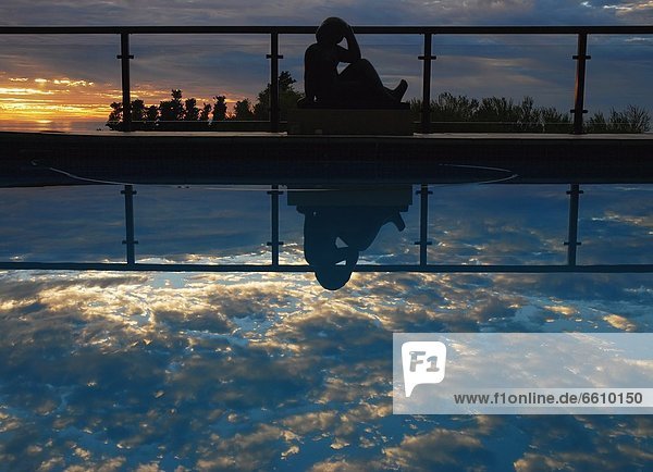 Woman Reflected In Swimming Pool At Dusk