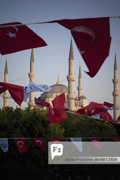 Turkish flags flap in the breeze at dusk over Blue Mosque