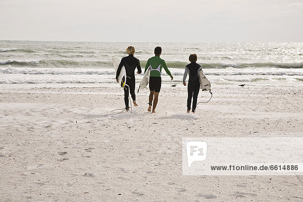 Three surfers on Lido Beach