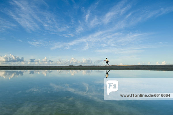 Man Walking Past Shallow Pond  Brighton Beach  Barbados. © Ian Cumming / Axiom