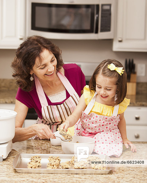 Caucasian grandmother and granddaughter baking cookies