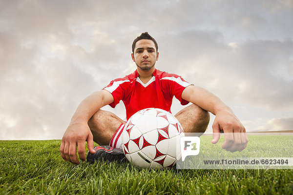 Fußballspieler sitzend Hispanier Ball Spielzeug