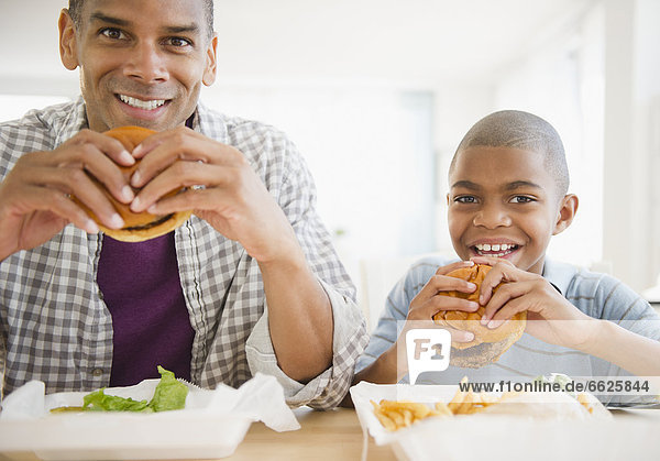 Father and son eating hamburgers