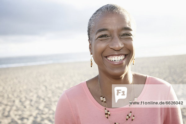 Smiling Black woman on beach