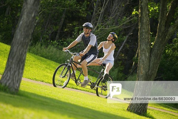 Happy Couple On A Tandem Bike