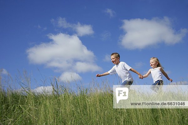 Boy & Girl Running In Tall Grass
