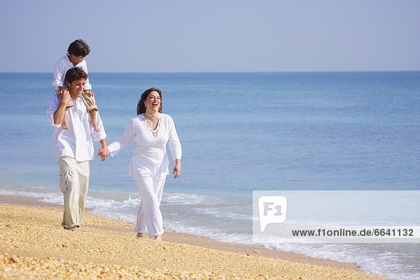 A Family Walks Along The Beach