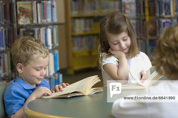 Children Reading At Library Table